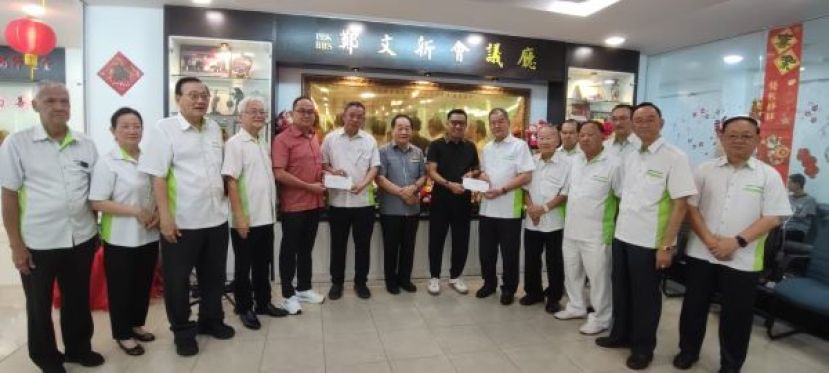 在主宾以及善堂理事的见证下，该堂名誉主席拿督龚财兴（左五）和拿督蔡传伟（左八）将各3000令吉支票移交给筹委会主席刘顺荣和主席郑文新，作为布施活动之经费时影。