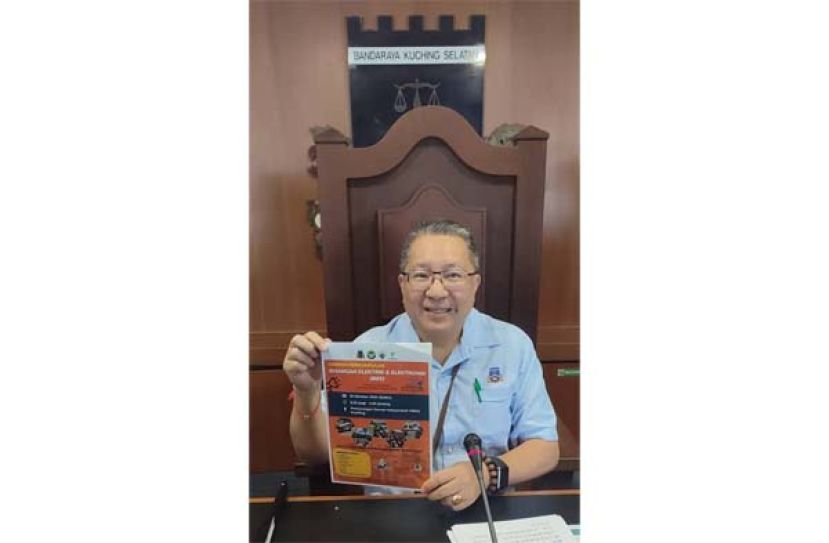 古晋南市市长黄鸿圣展示回收废弃电器及电子海报时影。