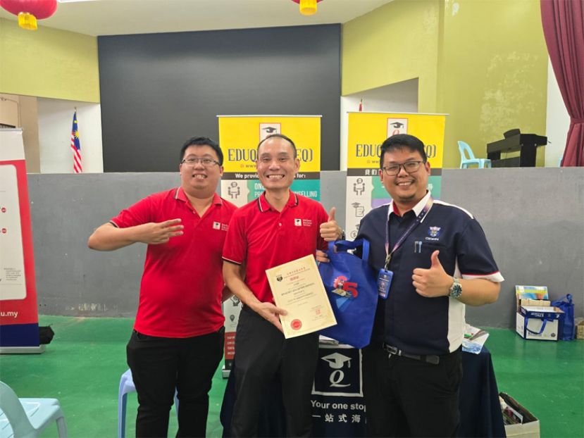 四中辅导主任杨益堃老师移交感谢状给古晋EduQuest负责人俞宏泰。