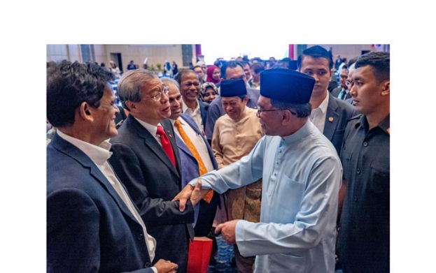 首相安华出席2024财政预算案会议，与与会者寒暄。