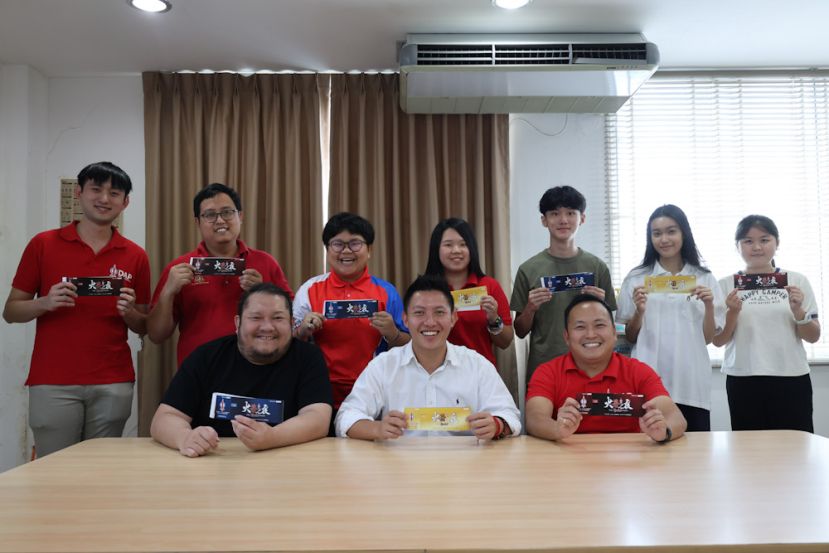 前排中为筹委会主席沈杰龙，右为秘书江峰年，左为宣传陈祥声，三人与其他筹委会成员一道，联合推介筹款晚宴票务。