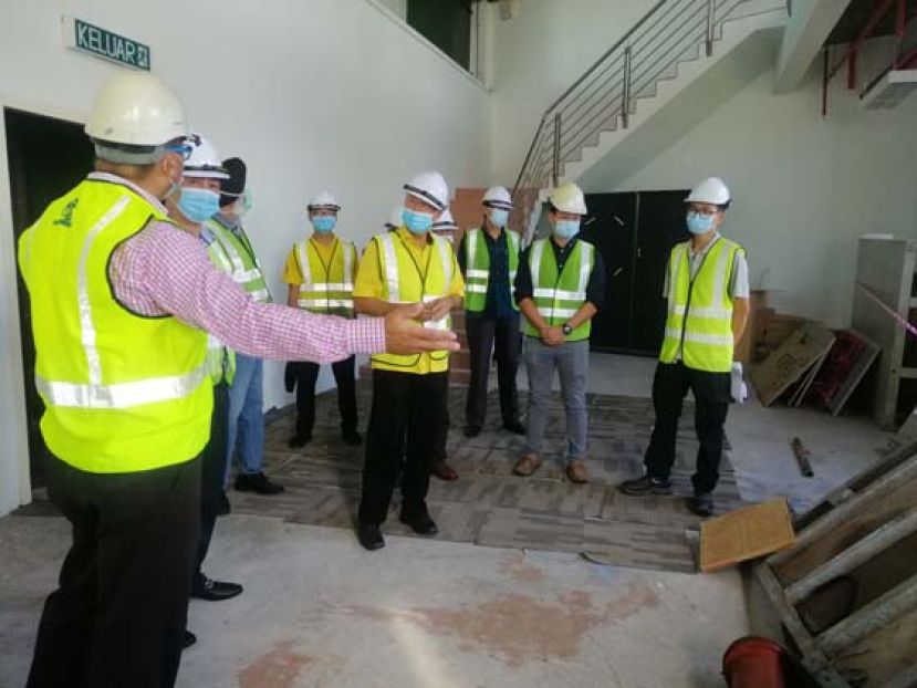 美里省工程师张志凡(左)向陈超耀讲解美里石油博物馆空调系统提升工程进度。