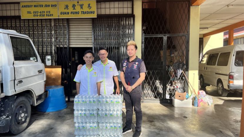 源丰贸易号东兼刘青团署理团长刘室锋（中）移交赞助矿泉水。左为刘青团秘书刘威荣。右为华青团福利组组长郑建宏。