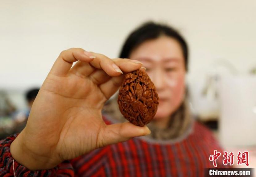 河北省廊坊市永清县别古庄镇的一家核雕工作室内，雕刻师展示自己的核雕作品。
