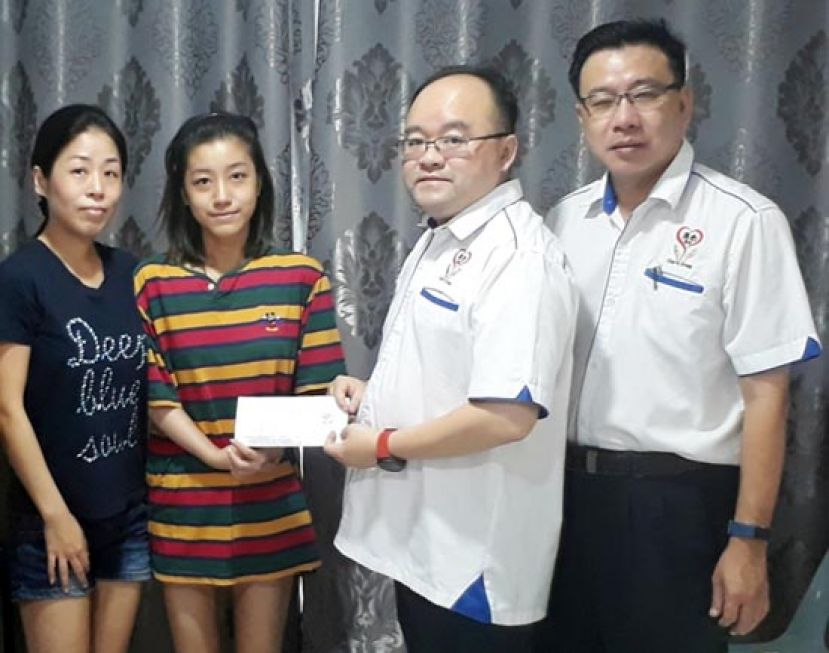 甲必丹拿督刘思乐（右二）把善款交予钟惠棋时摄，左一;为田志和。