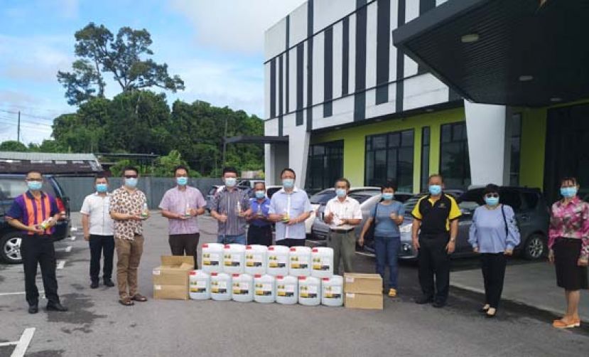 广德昌贸易公司董事经理张永丰（左五）在董联会蔡文铎（左七）和秘书长贝文美（右五）等的见证下，移交防疫用品。