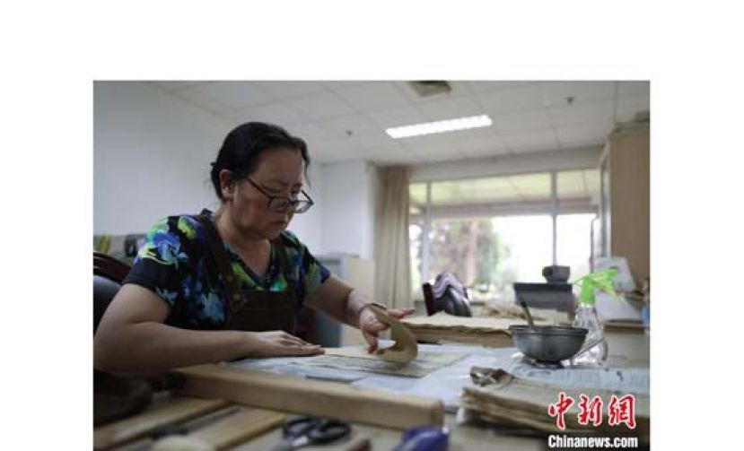 尹光华正在修复古籍。