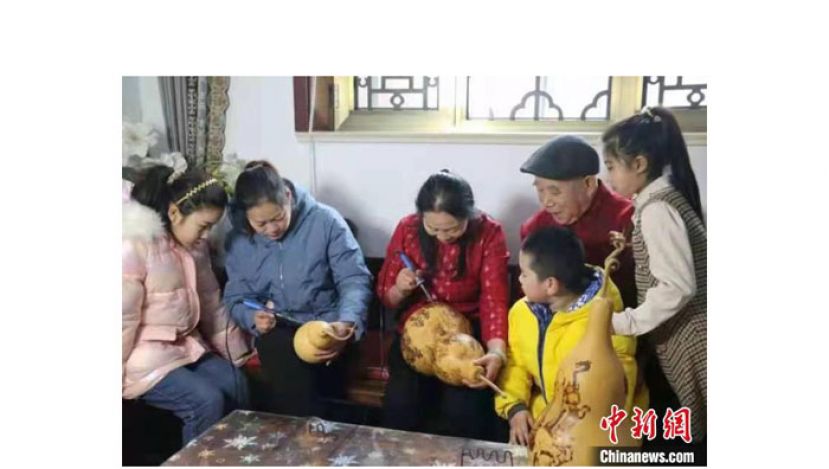 薛改莲在葫芦上烙画。