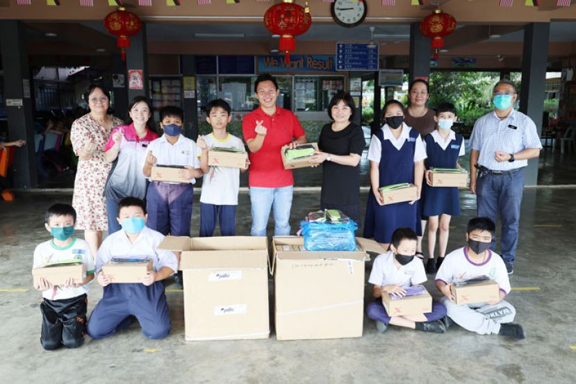 实旦宾区国会议员张健仁特别助理沈杰龙（第二排左5）象征式移交新校鞋及文具给十哩中公的校方代表后，与师生们合影。