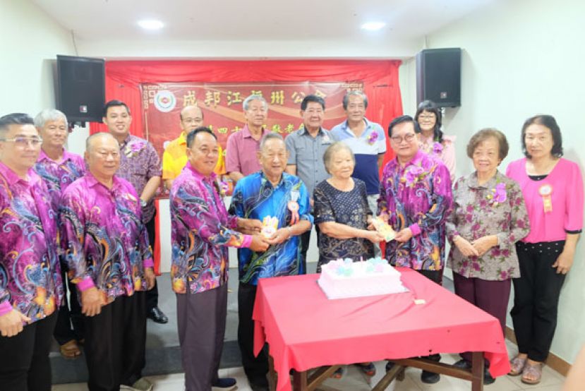 吴标生(右三)及黄天明(左三)分别颁赠最年长寿母寿翁红包予许赛莺及龚招平。