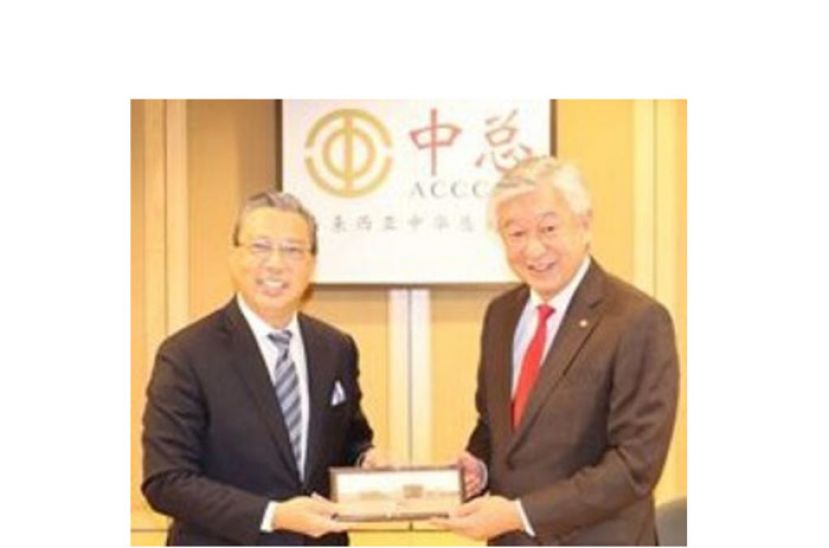 丹斯里卢成全（右）赠送纪念品予廖中莱。