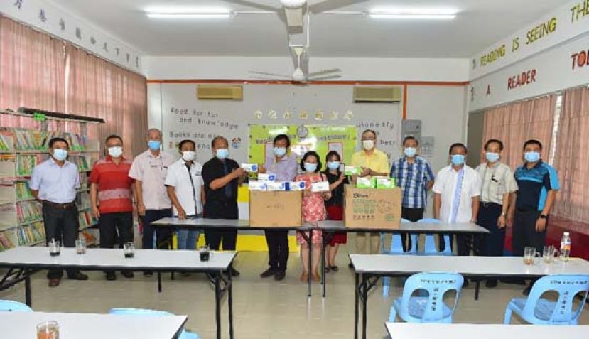 古晋中华小学校董会主席拿督王长福（左6）移交口罩予校方。