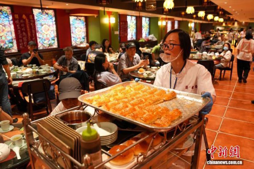5月11日，莲香楼上环新店正式开业，店员推着手推车向食客售卖点心。