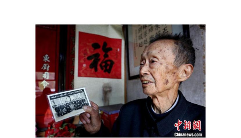 周海臣拿着老照片回忆往事。