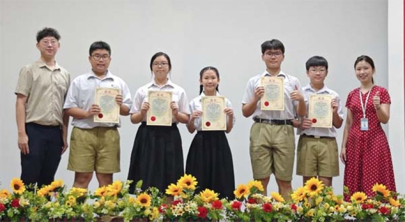 校长赖淑珍(右一)与初中组三语演讲比赛获奖学生合影。