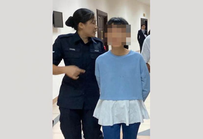 涉嫌以肉刀严重砍伤母亲的女嫌犯，在过堂后被押离法庭时摄。