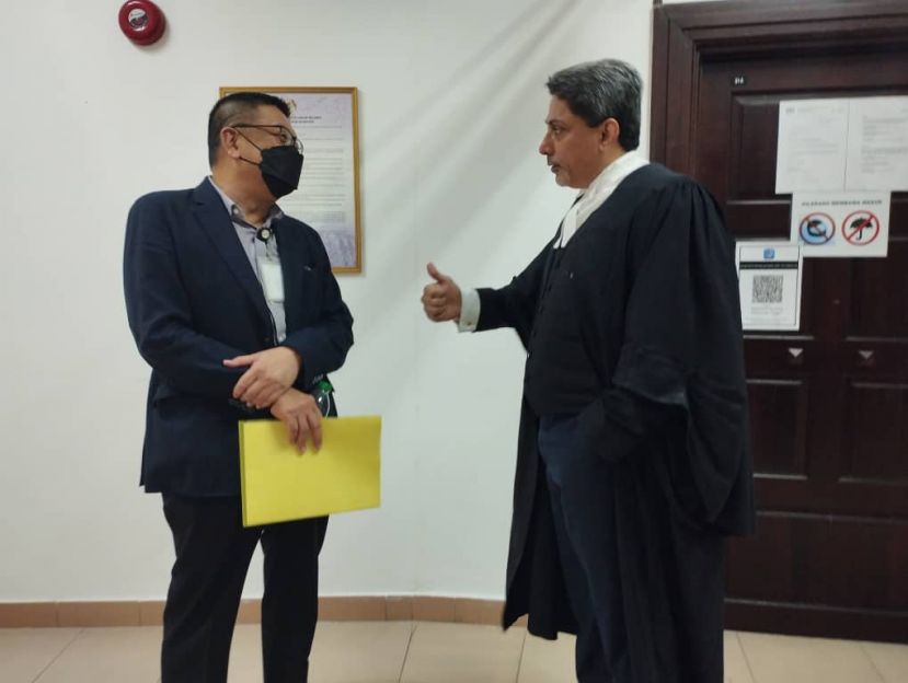 砂华总会长黄良杰（左）在庭外和代表律师商客隆交谈时摄。