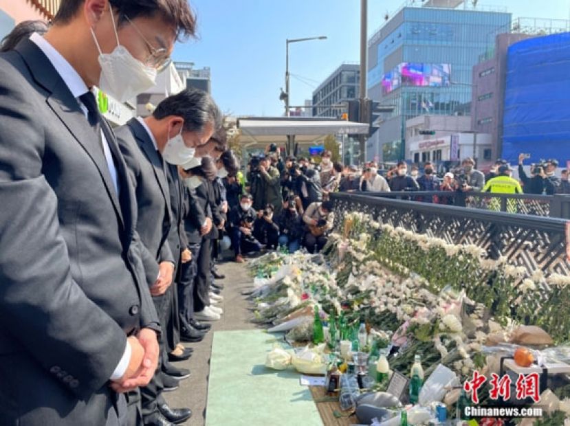 当地时间10月31日，韩国首尔市龙山区梨泰院站1号口，汉密尔顿酒店楼下，民众送来鲜花和祭品悼念遇难者。