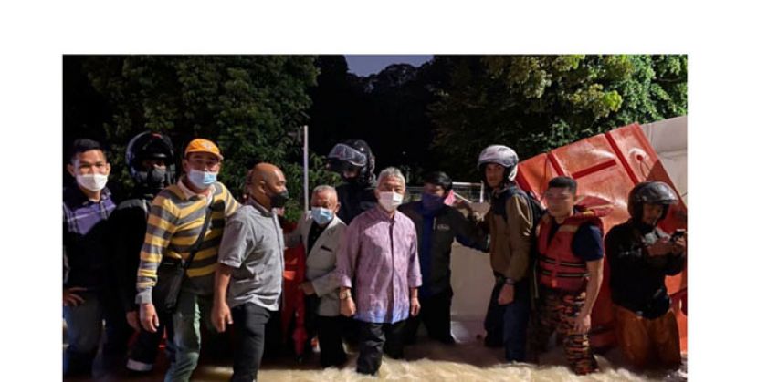 国家元首苏丹阿都拉漏夜涉水巡视灾区(档案图)。