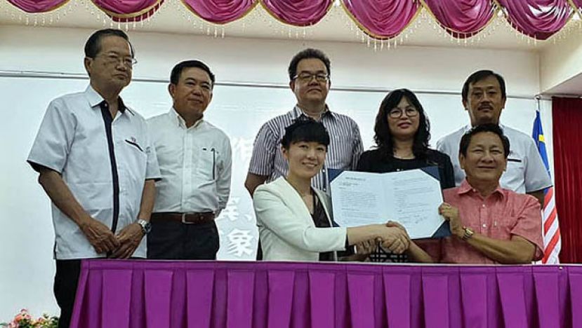 博赞万象教育导师杨艳艳（前排左）及古晋中华小学校董会主席王长福（前排右）等共同见证下双方交换协议书。后排(左起)为六小监学谢维光，校董会副主席蓝里安，秘书长田松茂，校长邓群娇及四小监学吴孟敦。