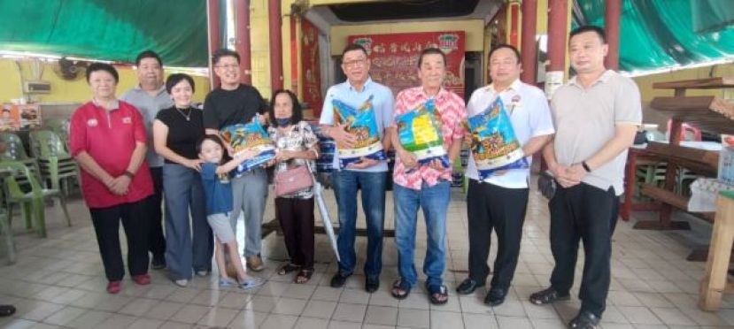 在众嘉宾见证下，沈光盛（左四）与夫人邢丽芯（左三）移交白米予受惠者。出席者包括（左起）风山寺管理小组组员李碧真、古晋福建公会财政洪清文，以及（右起）风山寺管理小组顾问吕世新、古晋福建公会秘书长甲必丹陈国璋、署理会长黄张金发与会长黄良杰。