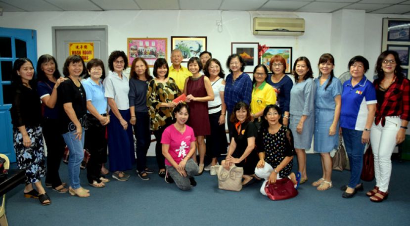 在陈超耀的见证下，27个舞蹈团体代表刘爱玉(左)移交善款予杨雅慧(右)。