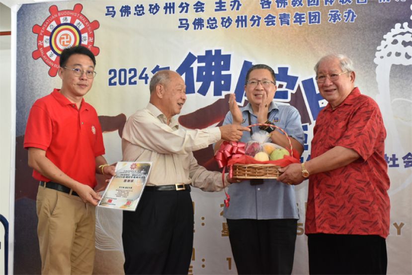 马佛总砂分会主席拿督斯里郑正金太平局绅（左二）赠送水果礼篮予活动总赞助人苏子灿（右一）。