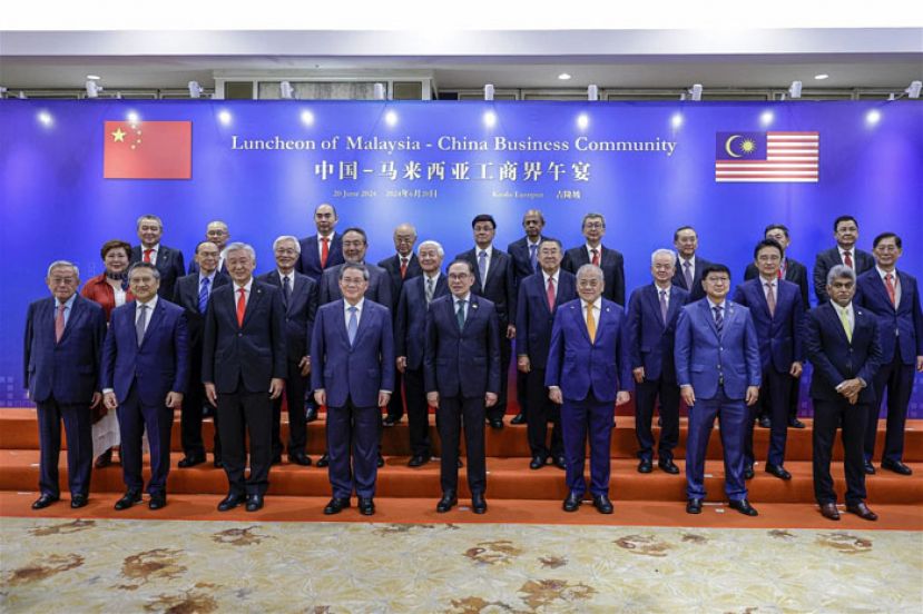 中国总理李强与大马首相安华与马中工商界领袖合影。