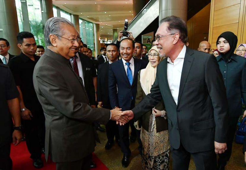 图：首相敦马哈迪在国家反贪蓝图推介礼上与人民公正党主席拿督斯里安华握手。中为副首相旺阿兹莎。
