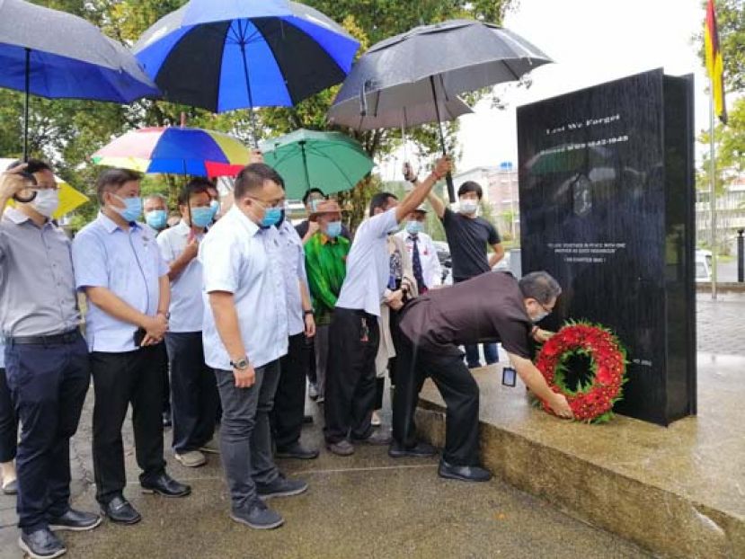 古晋南市市长拿督黄鸿圣在纪念碑前向二战英烈献花圈。