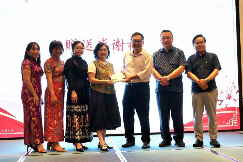张健仁（右3）在六小副主席周天龙（右起）、主席蔡文铎及一众六小副校长的见证与陪同下，移交支票予邓群娇（中）。