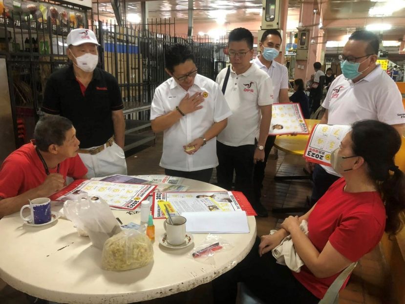 砂盟古晋市区国区候选人郑志国（左2）与其竞选团队在毕打拿菜市场饮食中心拜访选民。