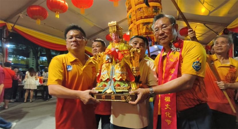 古晋海南公会主席张光福(前排右)与副主席符致宝(前排左)护驾妈祖金身抵达第3届婆罗洲妈祖文化节的举办地点毕打拿菜市场停车场临时神台帐篷。