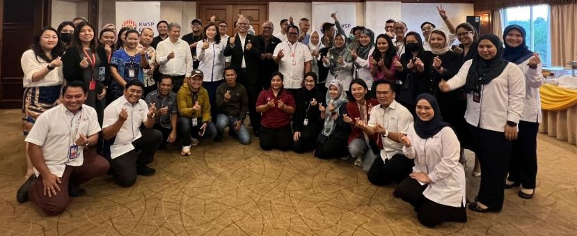 砂雇员公积金局局长阿米奴丁（中穿大衣）和该局官员及媒体合影、