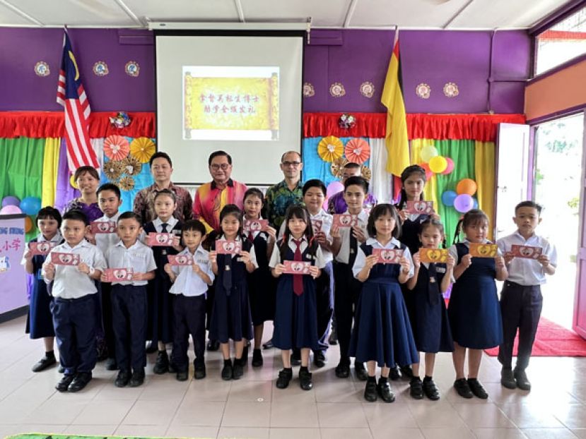 助学金受惠学生领奖后与赞助人吴标生（后左三）合影。