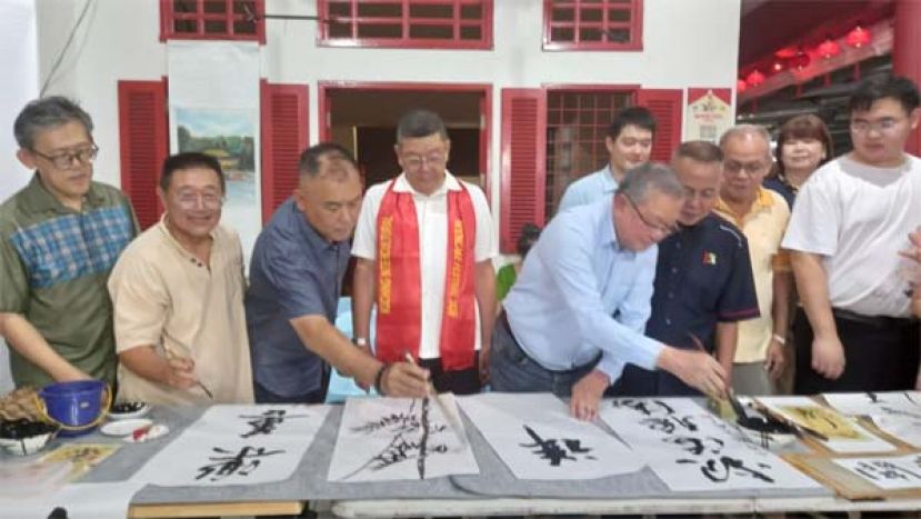 主宾拿督斯里黄良杰（左4）等人观赏古晋中华书画研究会会长田荣喜（左5）及沈冠名（左3）现场挥毫。左起为庆典顾问薛华东、李汉标；右4是庆典主席甲必丹林传政。