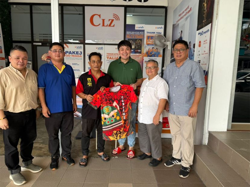 石角丰圣青狮王赖汉云接收CLZ Resources ( Sarawak) Sdn Bhd负责人江顺宏赞助的新制服，左一马来西亚客家文化协会（砂分会）秘书黄立达，石角丰圣青狮王代表赖穆春 （右）马来西亚客家文化协会（砂分会）署理会长温俊雄，砂分会会长罗如意博士。