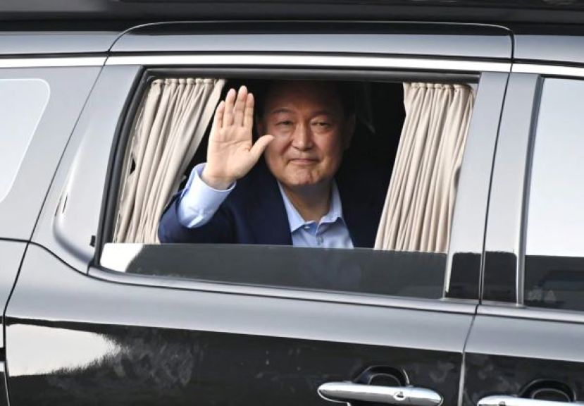 尹锡悦离开官邸时，在车里向支持者挥手致意。