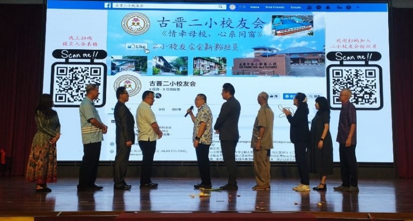 古晋南市市长拿督黄鸿圣（左五）为二小校友会粉丝页主持启用礼时影。