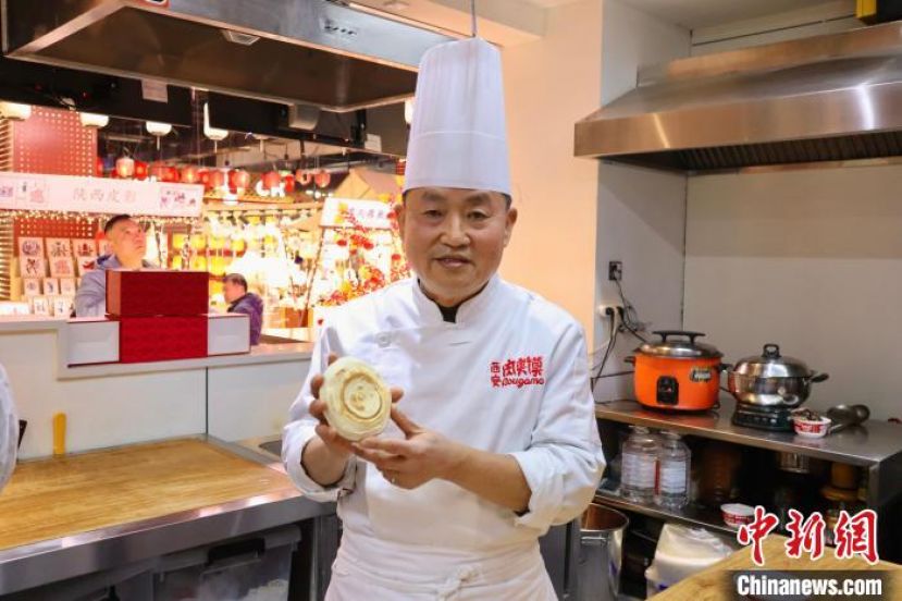 陕西省非遗项目&ldquo;西安肉夹馍&rdquo;代表性传承人廉守柱与他制作的白吉馍。