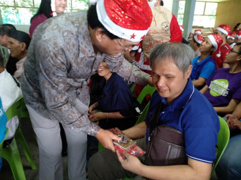 戴着圣诞帽的联邦工程部部长巴鲁比安派发礼物时攝 。