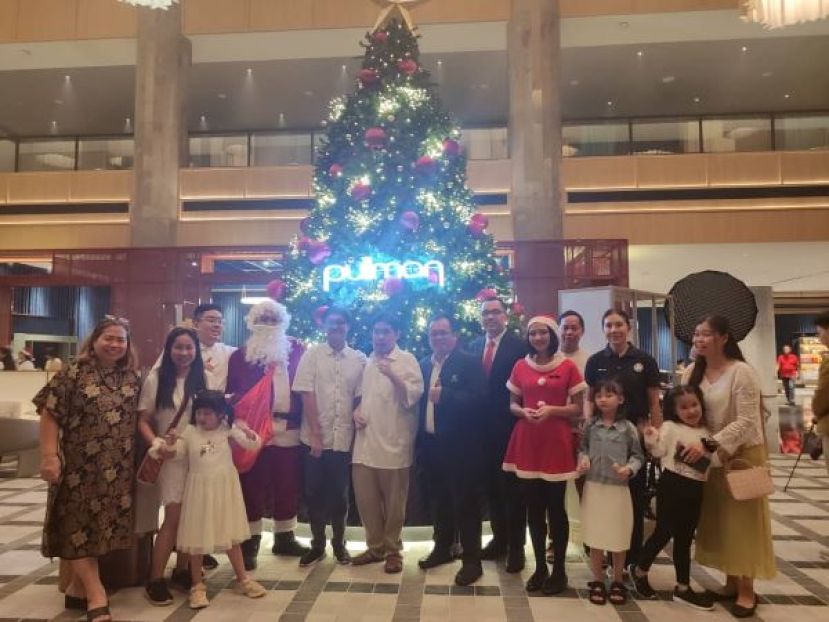 古晋自闭症协会理事和学生等和圣诞老人影于甫灯光亮起的圣诞树前合影。