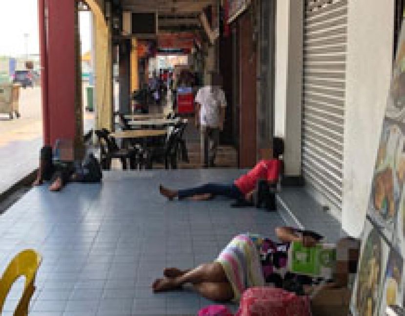 三五成群街头流浪者或躺或坐在商店的五脚基。