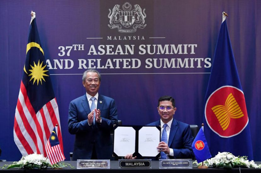 首相慕尤丁(左)见证阿兹敏签署&ldquo;区域全面经济伙伴关系协定&rdquo;（RCEP）后，展示签字文件。