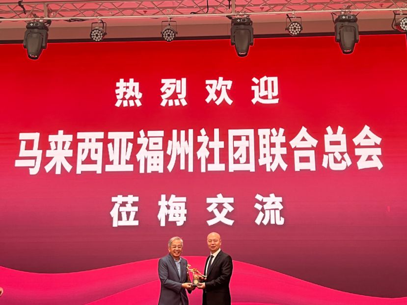 董仕星（左）赠送纪念品于东道主闽清县政府，并由县长陈禺（右）接过时摄。
