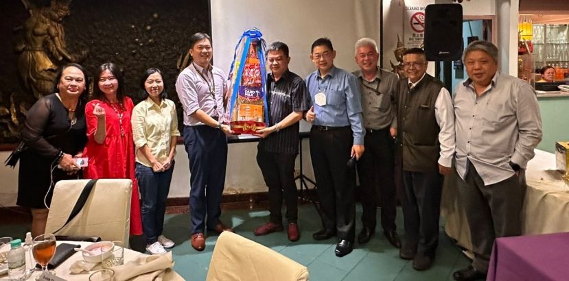 新闻从业员主席罗尼张（左四）颁发幸运抽奖礼篮予国际时报营业员杨晓扬时摄。右三为万能万字有限公司东马区副总裁刘其全、右四为该公司执行长拿督陈志辉以及左二位该公司品牌与集团社会责任主管马美莉副总裁 以及左三为砂总理署政治秘书许德婉