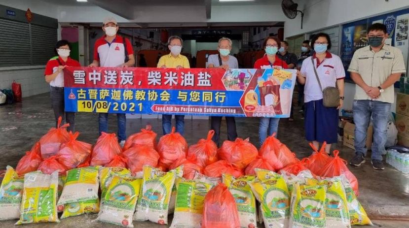 砂地方政府与房屋部部长拿督斯里沈桂贤（左三）见证下，古晋萨迦佛教协会主席吴喜龙与理事（左二）送粮食到火患灾黎安顿中心。