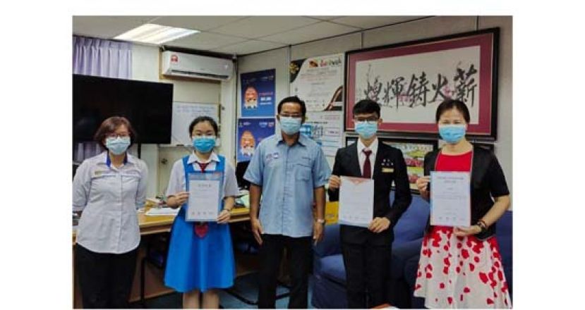 为美中争光的叶建均同学(右2)、池姿洁同学(左2)、李昔沄老师(右1)与翁义鸿校长(中)及副校长赖佳玲(左1)合摄。