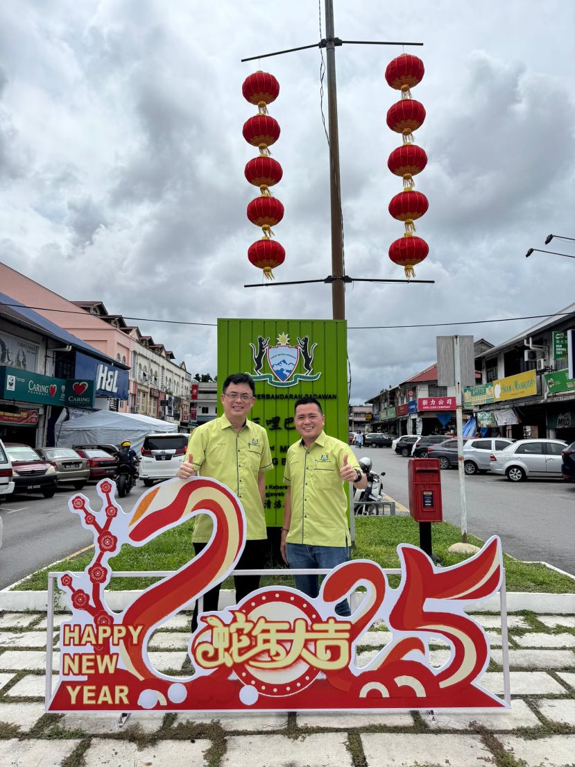 巴达旺市议会主席陈开与巴达旺市议员庄育华巡视古晋3哩老巴刹的新春佳节装饰。