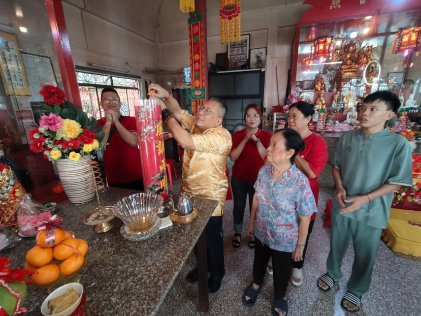 南市市长拿督黄鸿圣（中）在众善堂堂主梁秀群（右二）及斋姑苏宝慈（后排右二）、制作斗烛业者温靖海（左一）陪同下点燃&ldquo;风调雨顺 国泰民安&rdquo;斗烛。